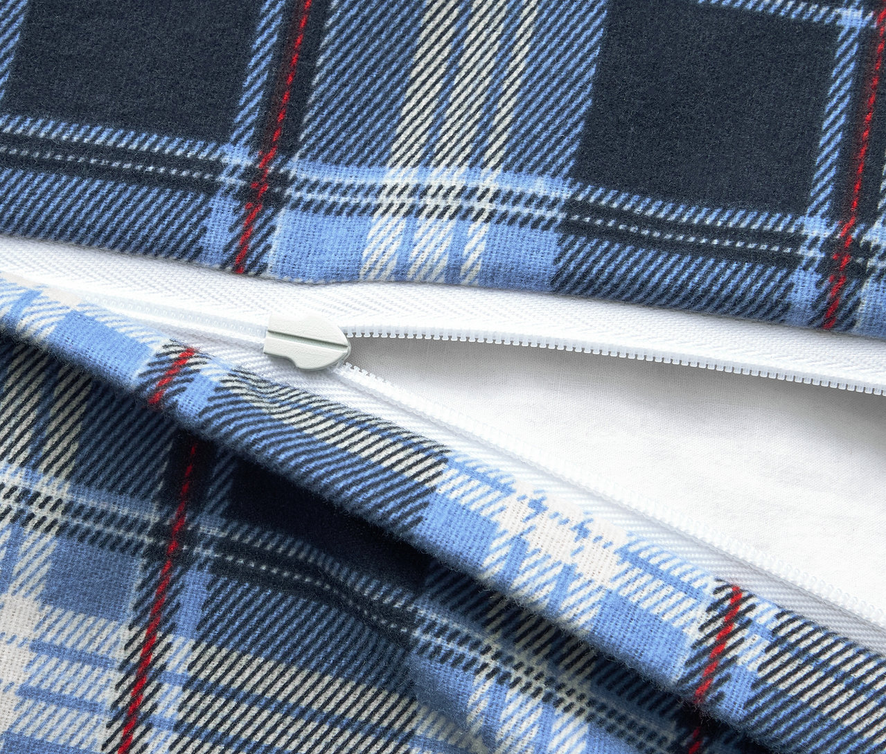 Kék kockás anyag részlete fehér cipzárral.