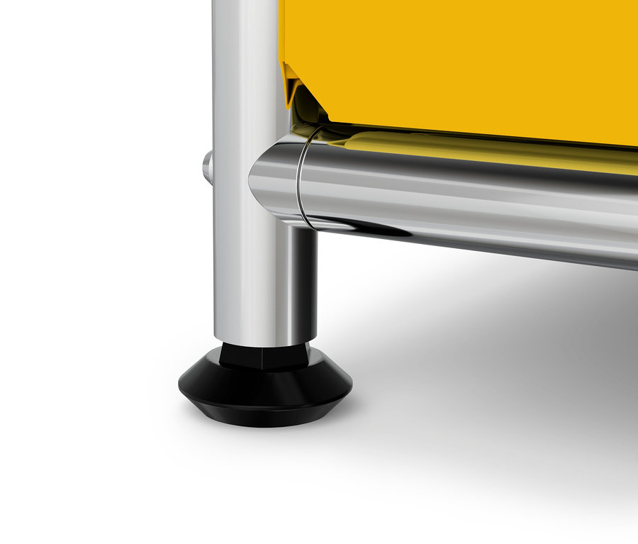 Sárga bútor részlete krómozott lábbal és fekete talppal.