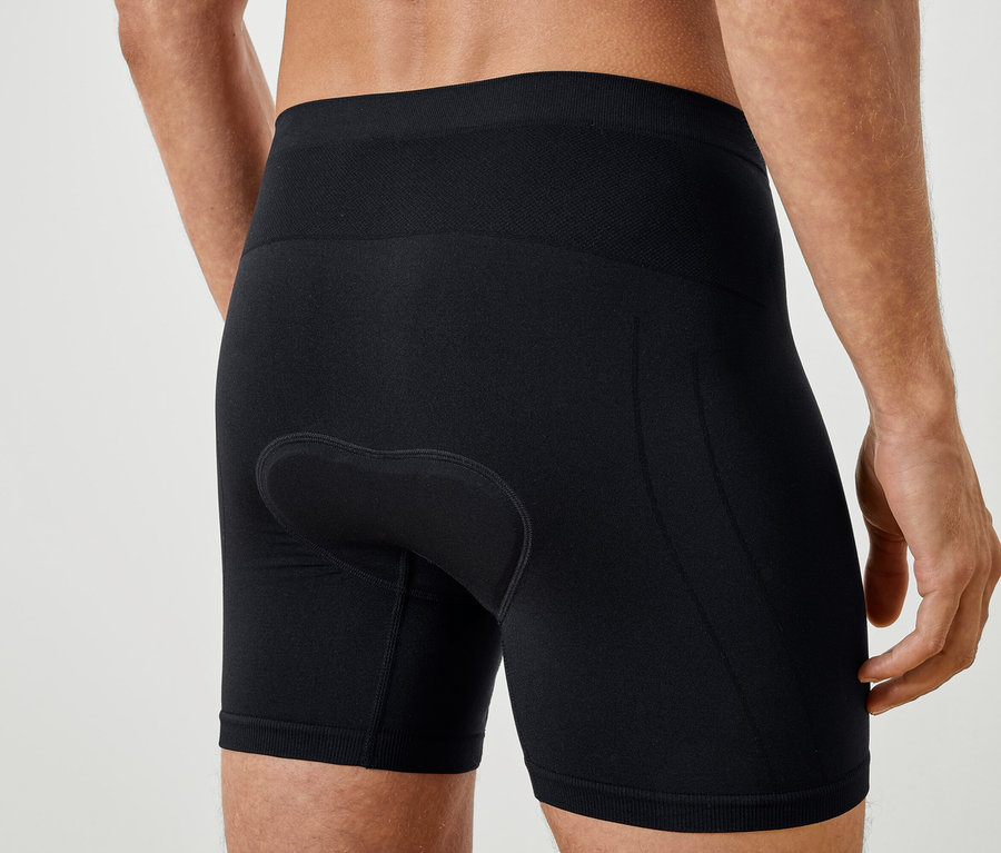 Közeli kép egy fekete biciklis rövidnadrágot viselő férfi hátáról.