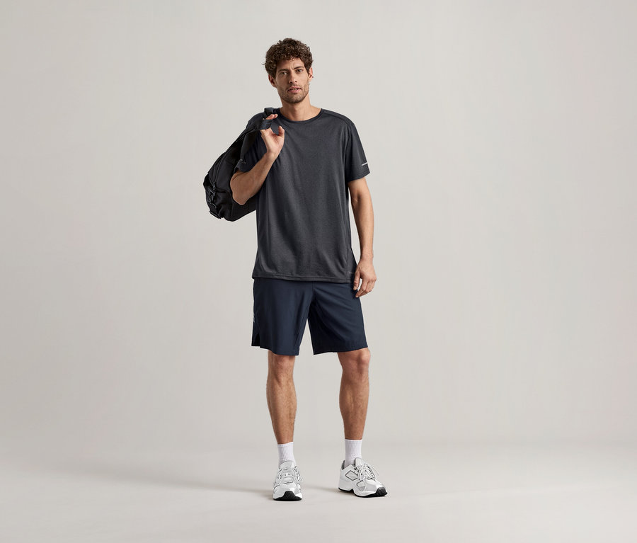 Férfi antracit színű sportfelsőben, sporttáskával a vállán.