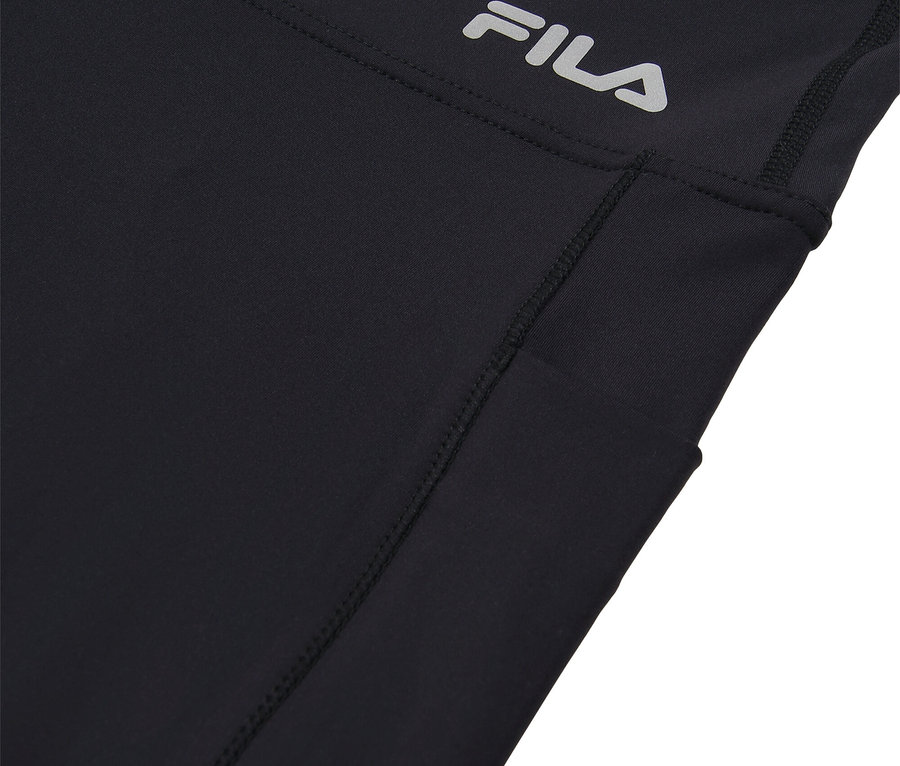 Egy fekete Fila sportnadrág részletfotója oldalzsebbel és ezüstszínű Fila logóval.