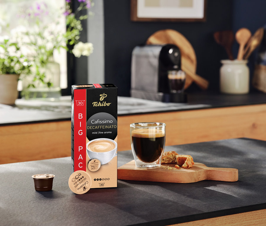 A pulton egy csomag Cafissimo Decaffeinato kapszula, egy csésze kávé és egy kapszula látható.