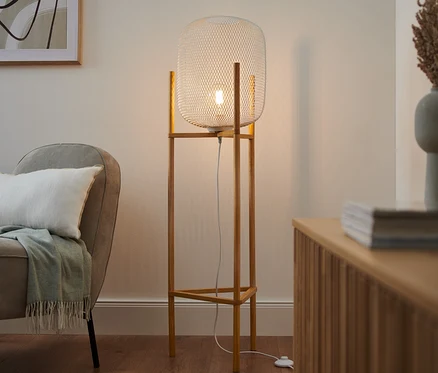 A nappaliban egy LED-es állólámpa áll, 3 lábú, fa/fém.