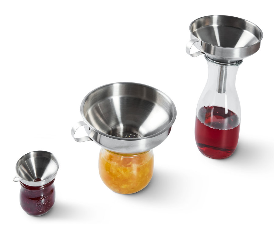 Rozsdamentes acél tölcsérek állnak lekváros üvegeken.