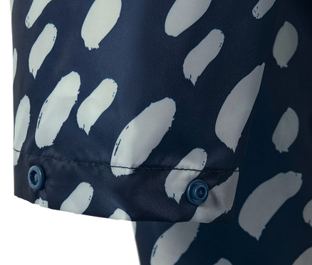 Egy sötétkék, mintás női poncsó esőkabát részlete, ujjakkal, patentos zárással.