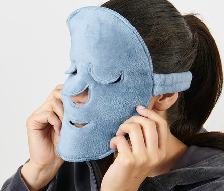 Nő világoskék 2 arcmaszkot tesz az arcára.