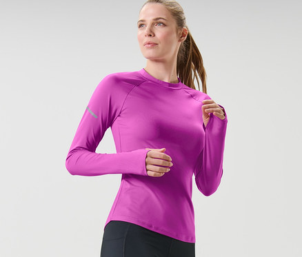 Nő fekete leggingsben és lila, hosszú ujjú funkcionális felsőben fut.