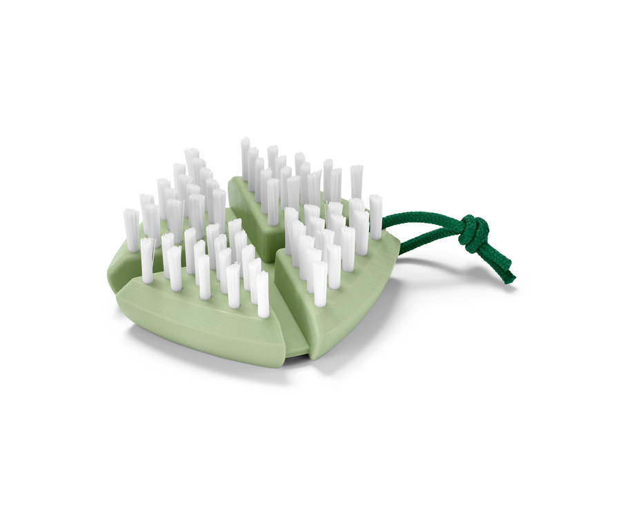 Egy zöld, hajlékony kefe zöldségek és gyümölcsök tisztításához, fehér sörtékkel és zöld zsinórral.