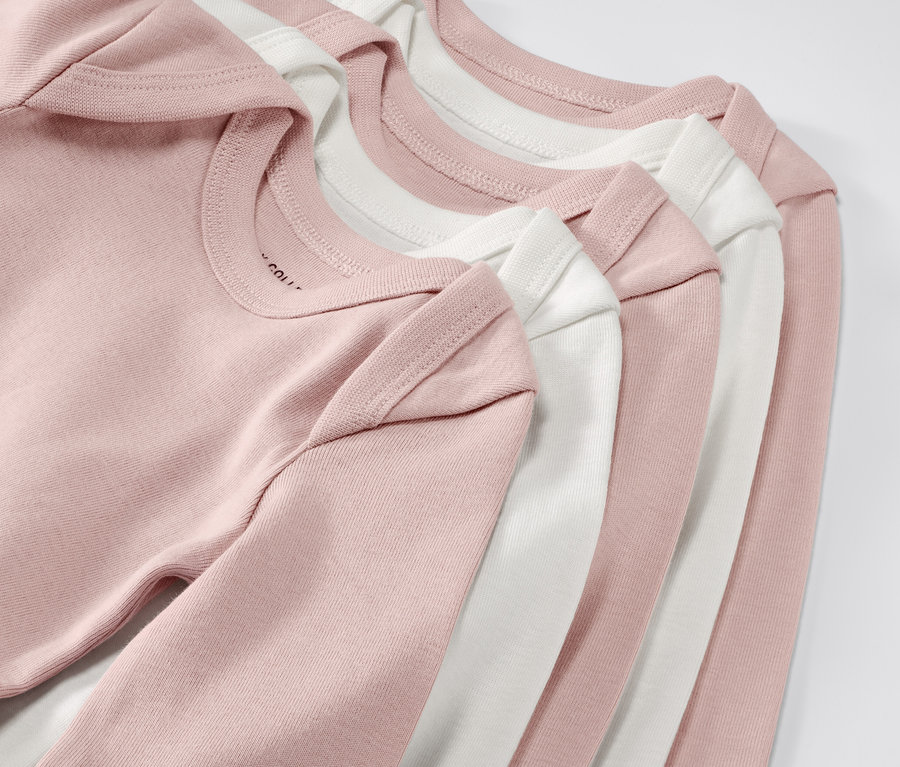 Öt darab rózsaszín és fehér, állítható hosszúságú kisgyerek body közelről. 5 kisgyerek body állítható hosszúsággal, rózsaszín.