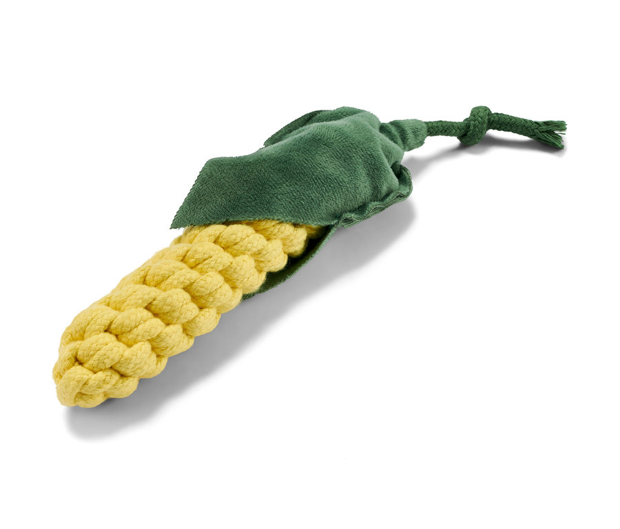 Egy kukorica alakú kutyajáték fekszik egy fehér háttéren.