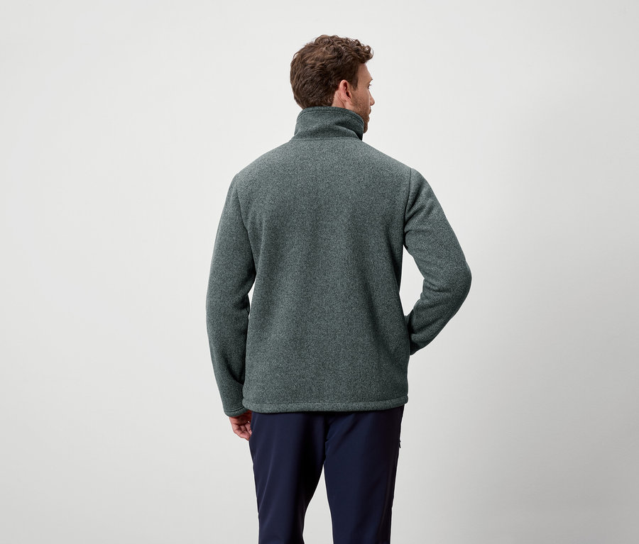 Hátulról látható férfi szürkészöld fleece pulóvert és sötétkék nadrágot visel.