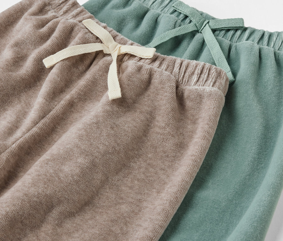 Két Baby-Pull-on-Pants részlete, egy bézs és egy zöld.
