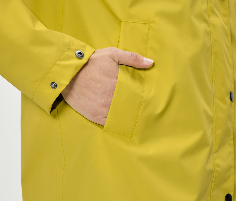 Kéz egy sárga kabát zsebében.