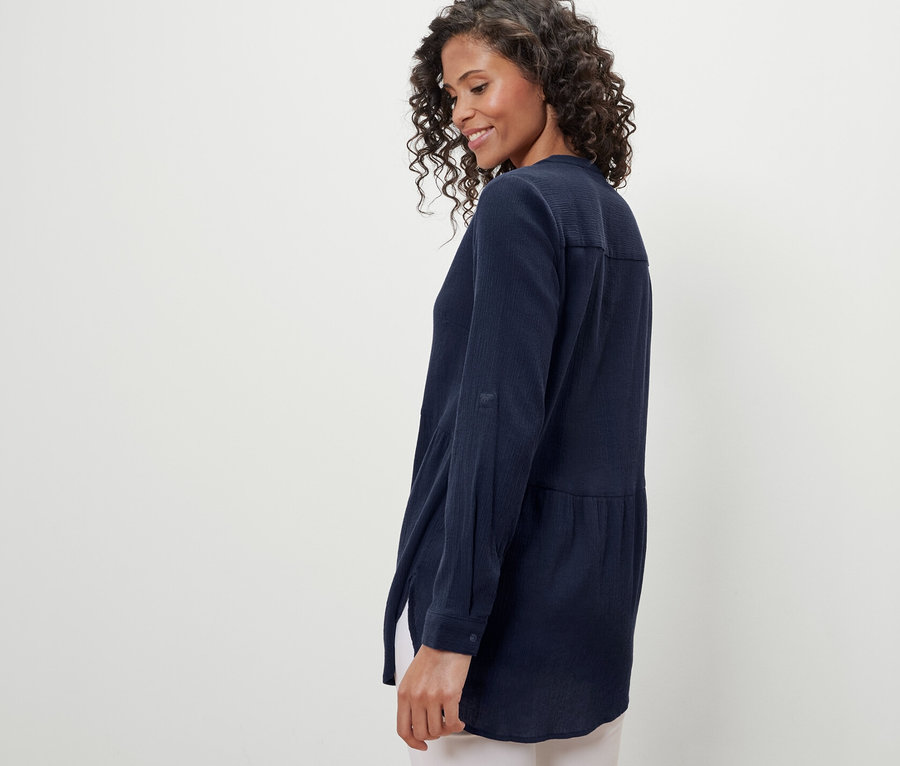 Nő visel egy sötétkék hosszú tunikablúzt.