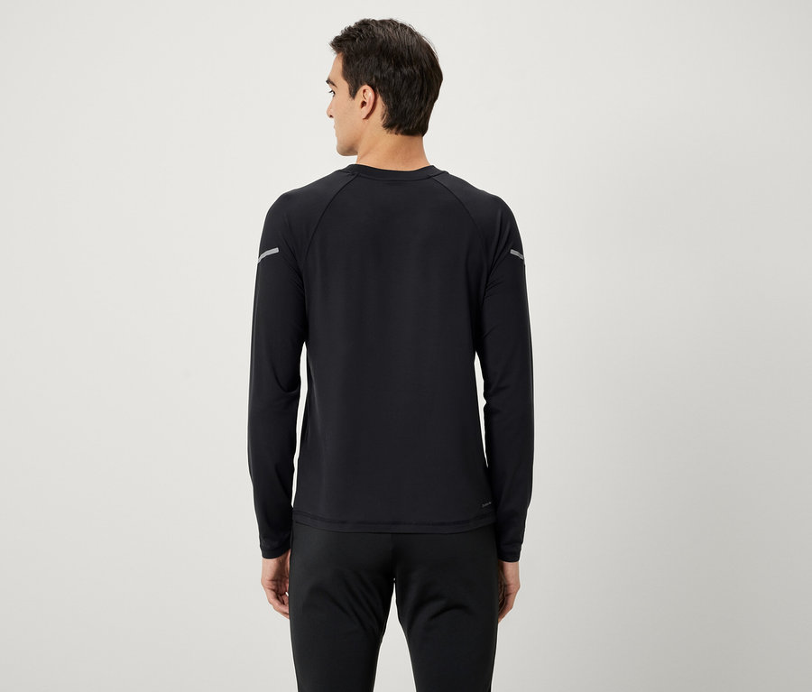 Egy férfi hátulról fekete hosszú ujjú inget és fekete melegítőnadrágot visel.