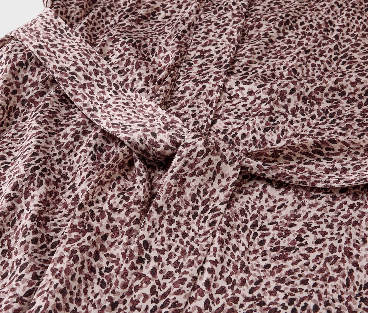 Közeli kép egy barna foltos mintázatú anyagról, csomóval.