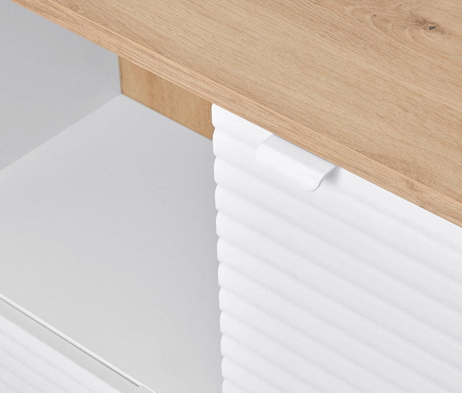 Egy fehér szekrény részletfotója fa asztallappal.