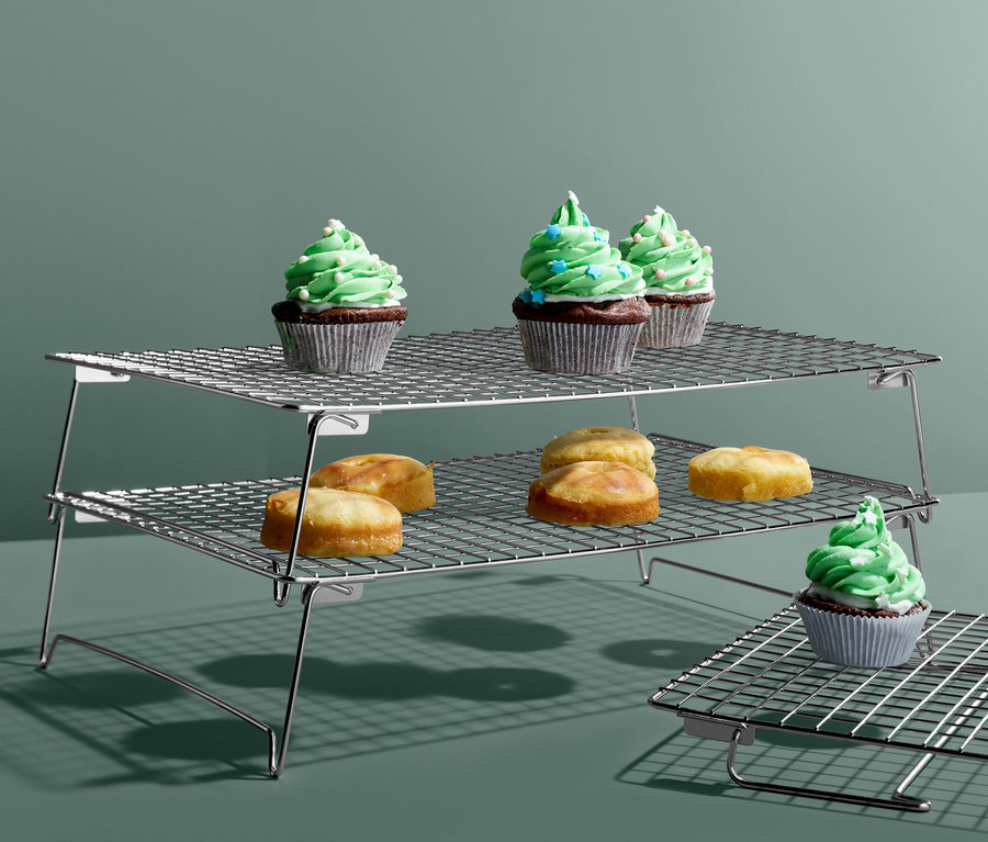 Cupcakes és kis sütemények egy háromszintes hűtőrácson.