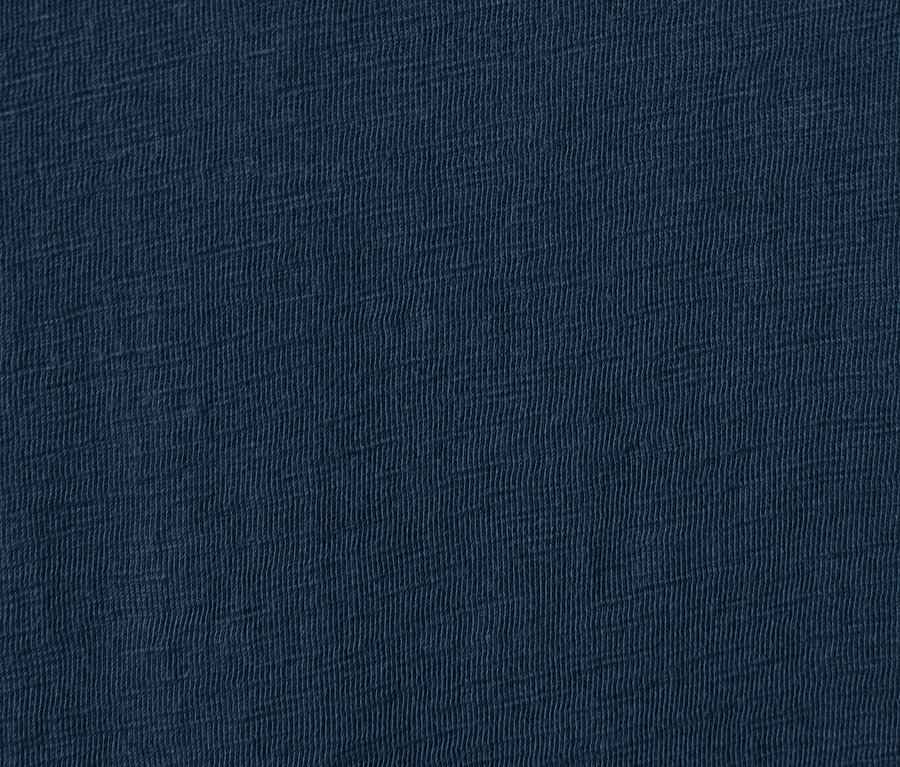 Közelkép a fodros, sötétkék női ruha anyagáról.