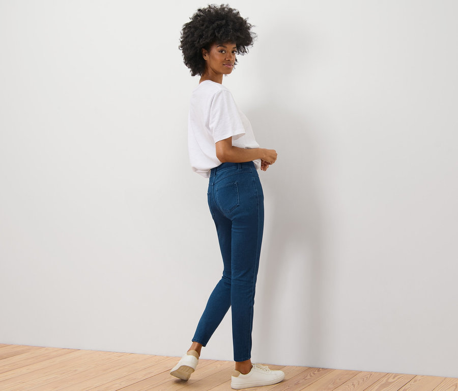 Egy nő a válla fölött hátra néz, és jeggingsben pózol.