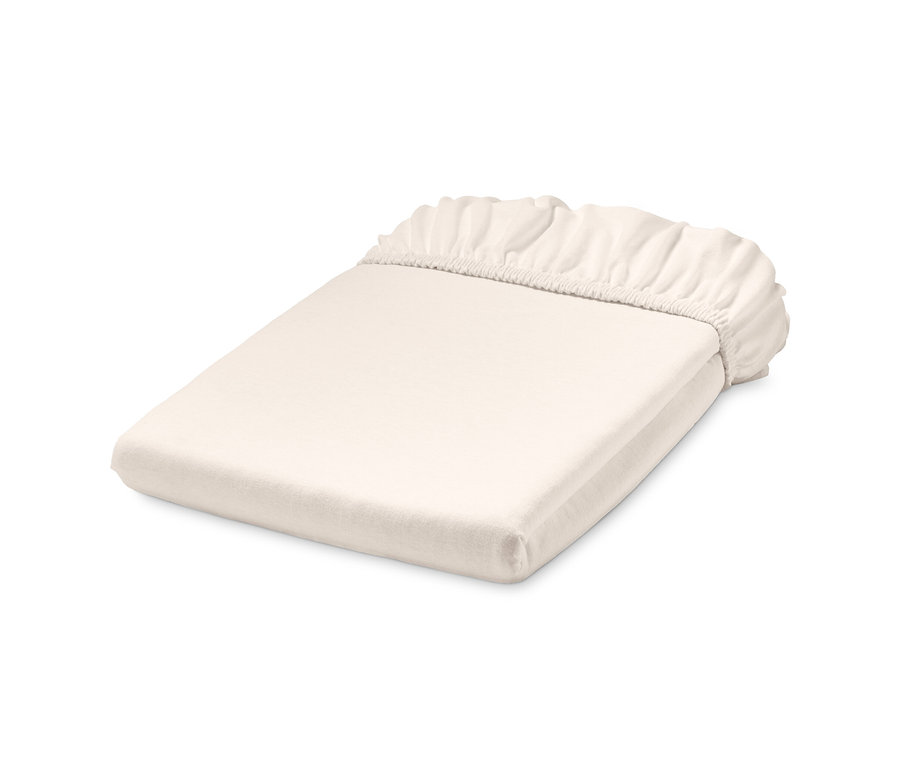 Összehajtott, fehér, normál méretű gumis jersey lepedő.