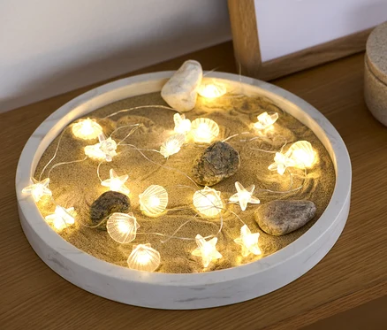LED-es mikro égősor, 20 kagyló homokon fekszik egy dekoratív tálban.