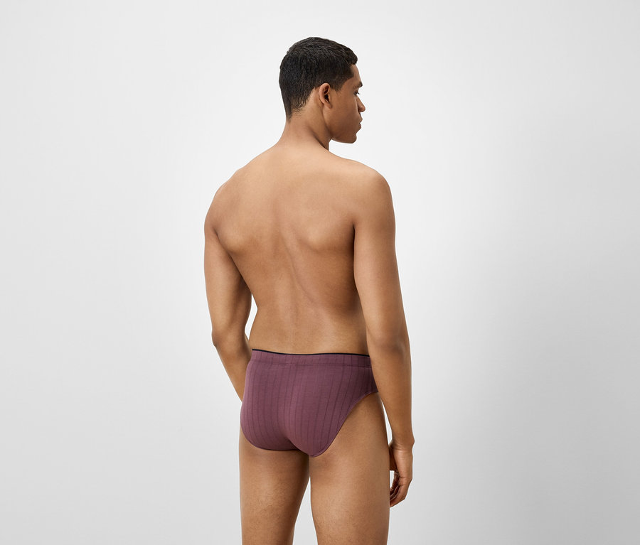 Férfi hátulról, bordó alsónadrágot visel.