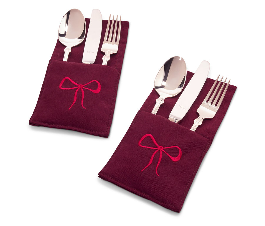 Két evőeszközkészlet bordó színű textil tokban, piros masnival hímezve.