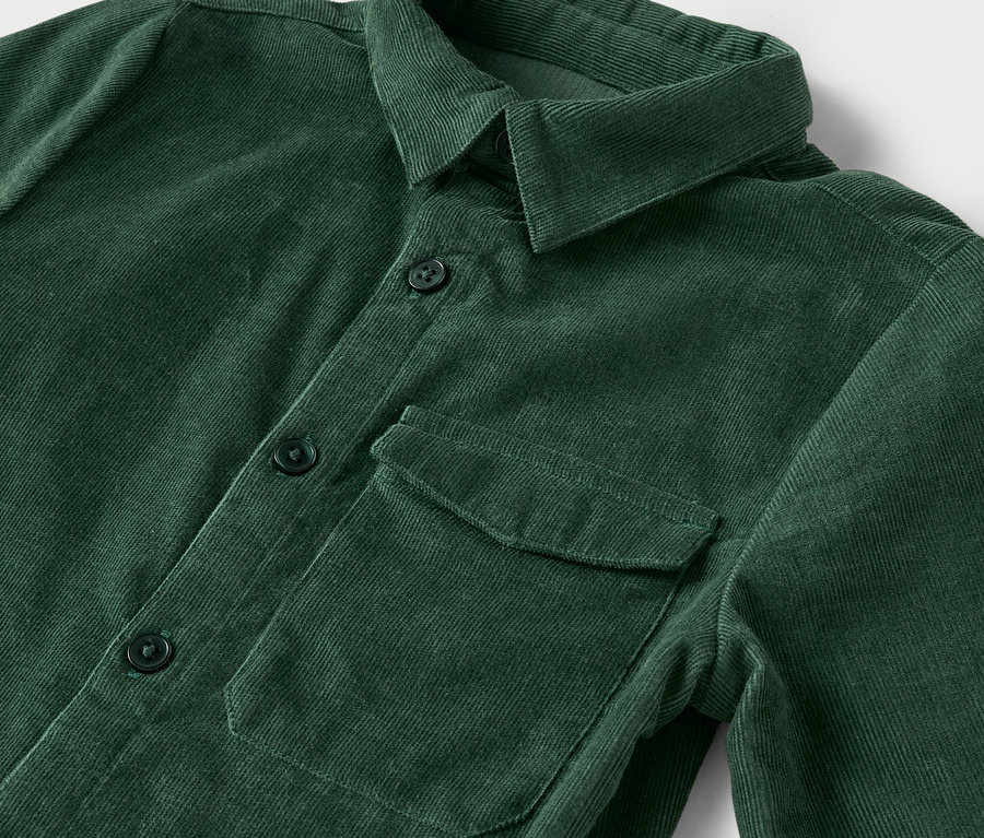 Egy zöld, gombos, mellzsebes kordbársony ing részlete.
