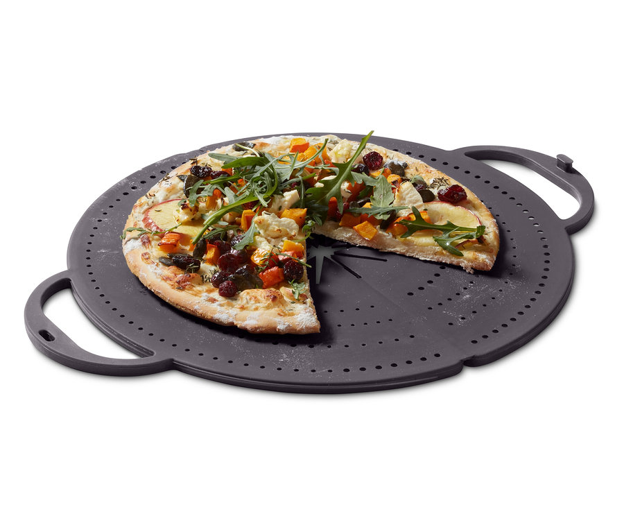 Őszi zöldséges pizza egy szürke, lyukacsos tálcán.