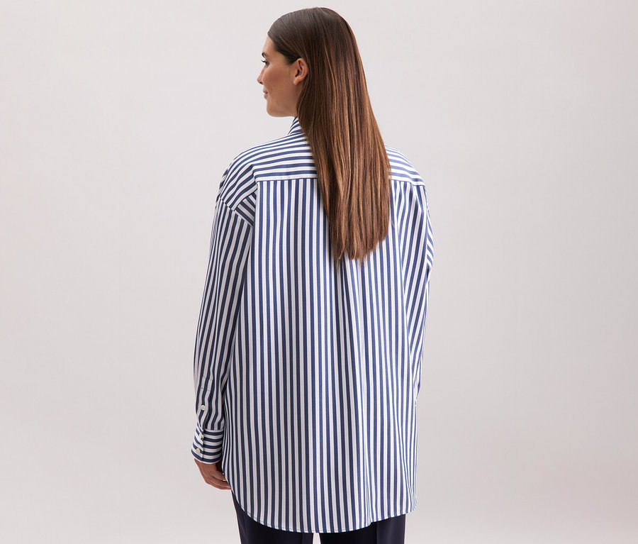 Hátulnézetből egy nő csíkos Seidensticker túlméretes hosszú ingblúzban.