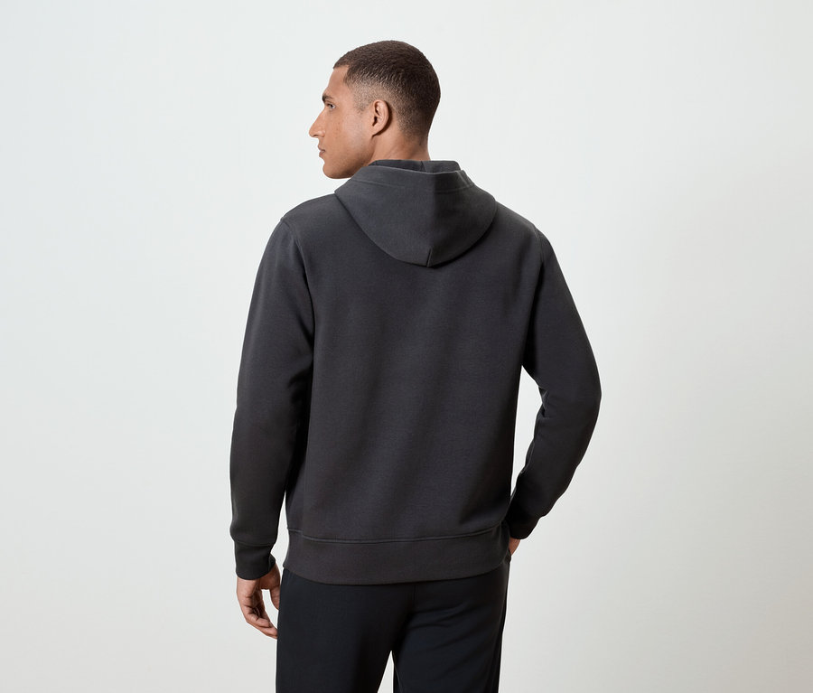 Férfi hátulról sötétszürke kapucnis pulóvert visel.