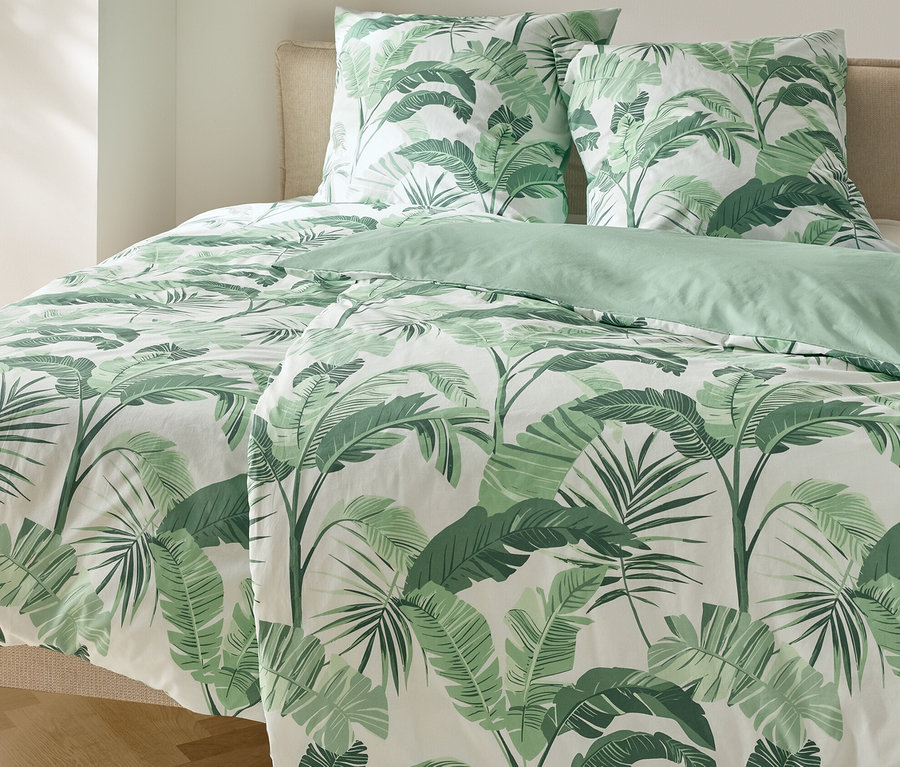 Ágy pálmamintás renforcé ágyneművel és két párnával.