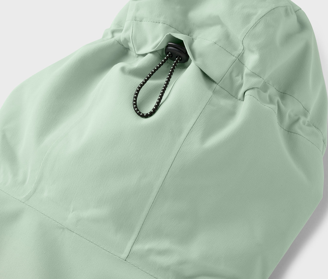 Világoszöld kabát kapucnijának részlete összehúzózsinórral.