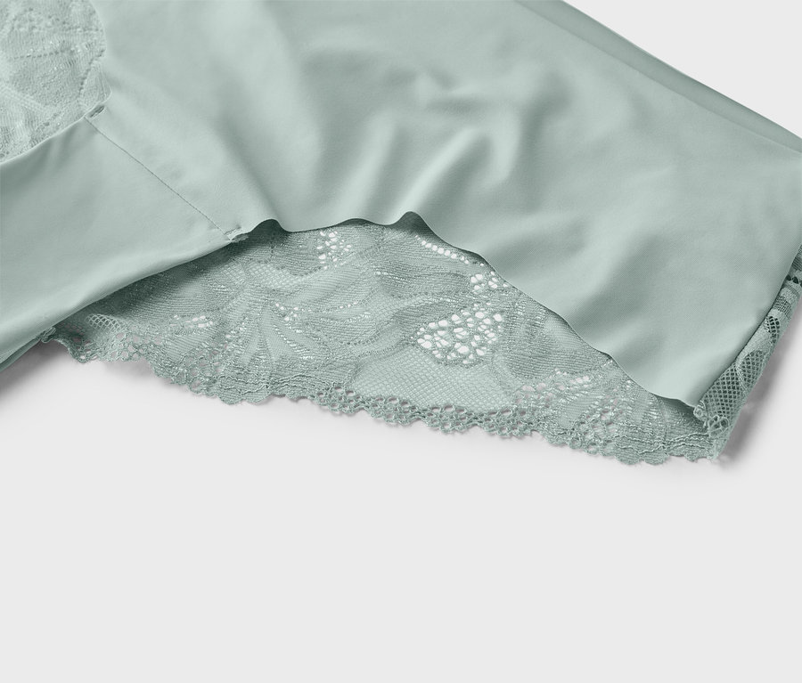 Közelkép egy mentazöld csipkés részletekkel díszített alsóneműről.