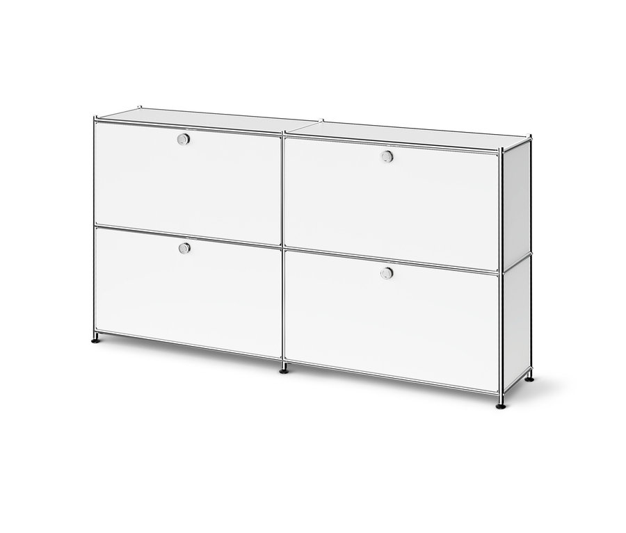 Fehér moduláris szekrény króm kerettel, négy rekesszel, mindegyik ajtóval és kerek fogantyúval, rövid fekete lábakon állva.