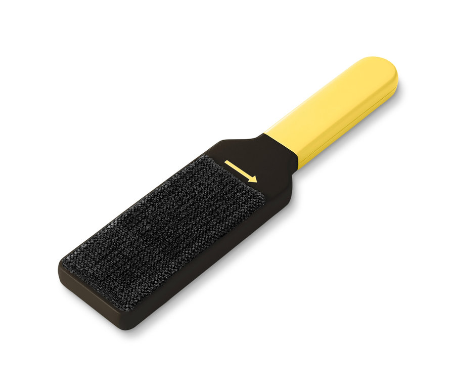 Egy sárga-fekete kétoldalas ruhatisztító kefe fekszik egy fehér háttéren.