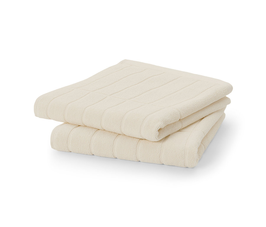 Két krémfehér prémium törölköző egymásra hajtva.