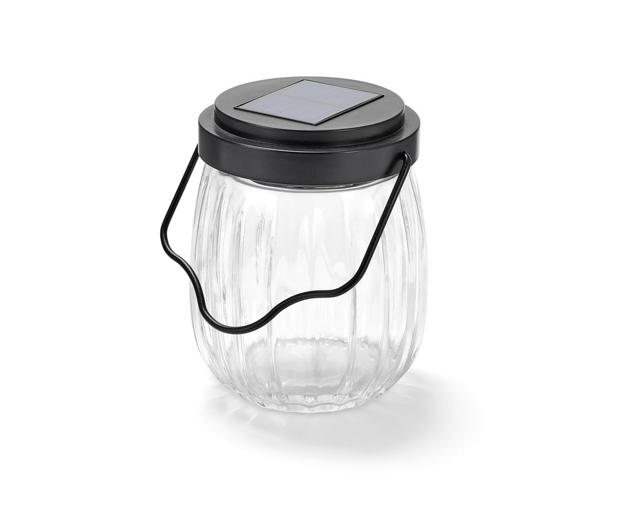 Egy üveg napelemes lámpa fekete fogantyúval.