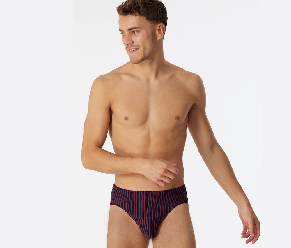 Férfi pózol piros Schiesser szuper mini biopamut alsóban.