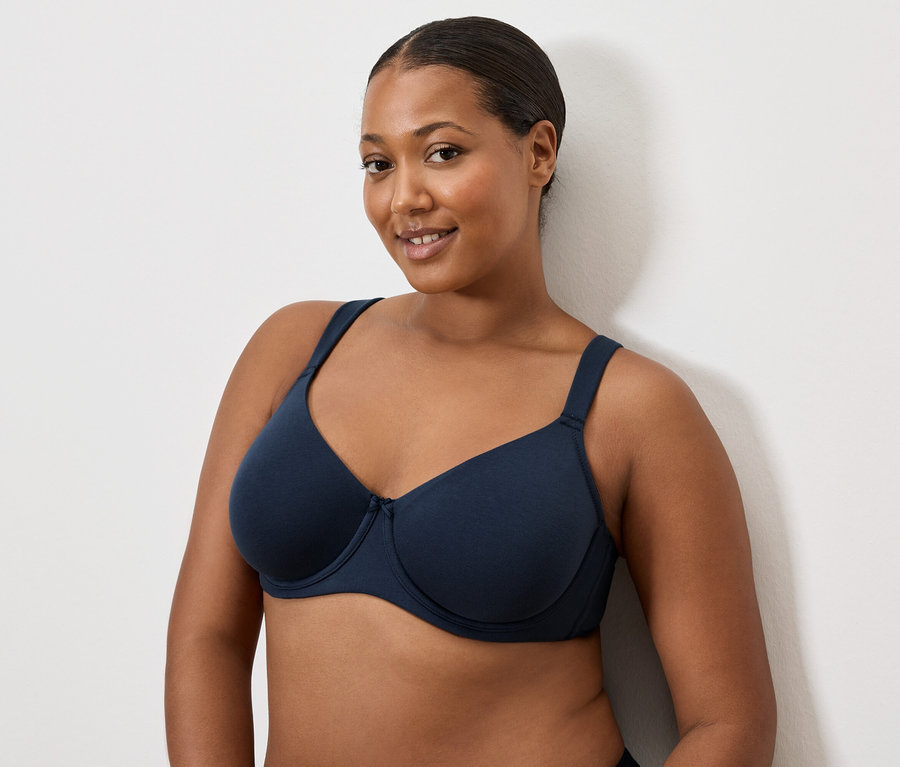 Sötét hajú nő sötétkék melltartót visel.