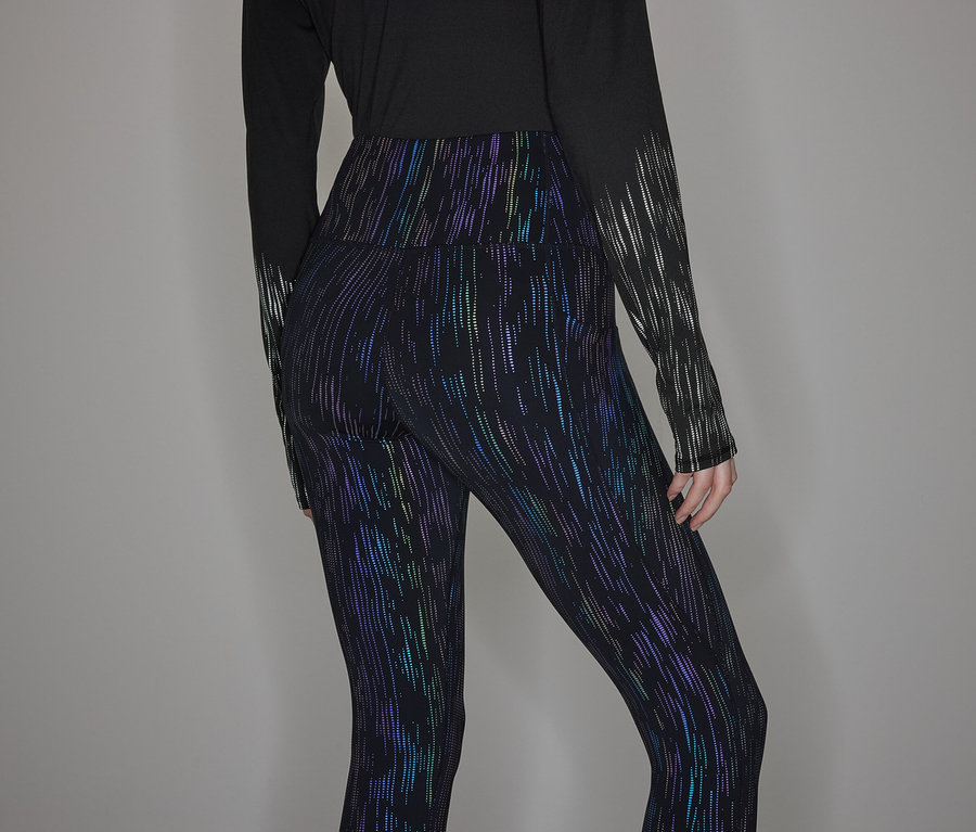 Egy személy fekete hosszú ujjú inget és fényes leggingset visel.