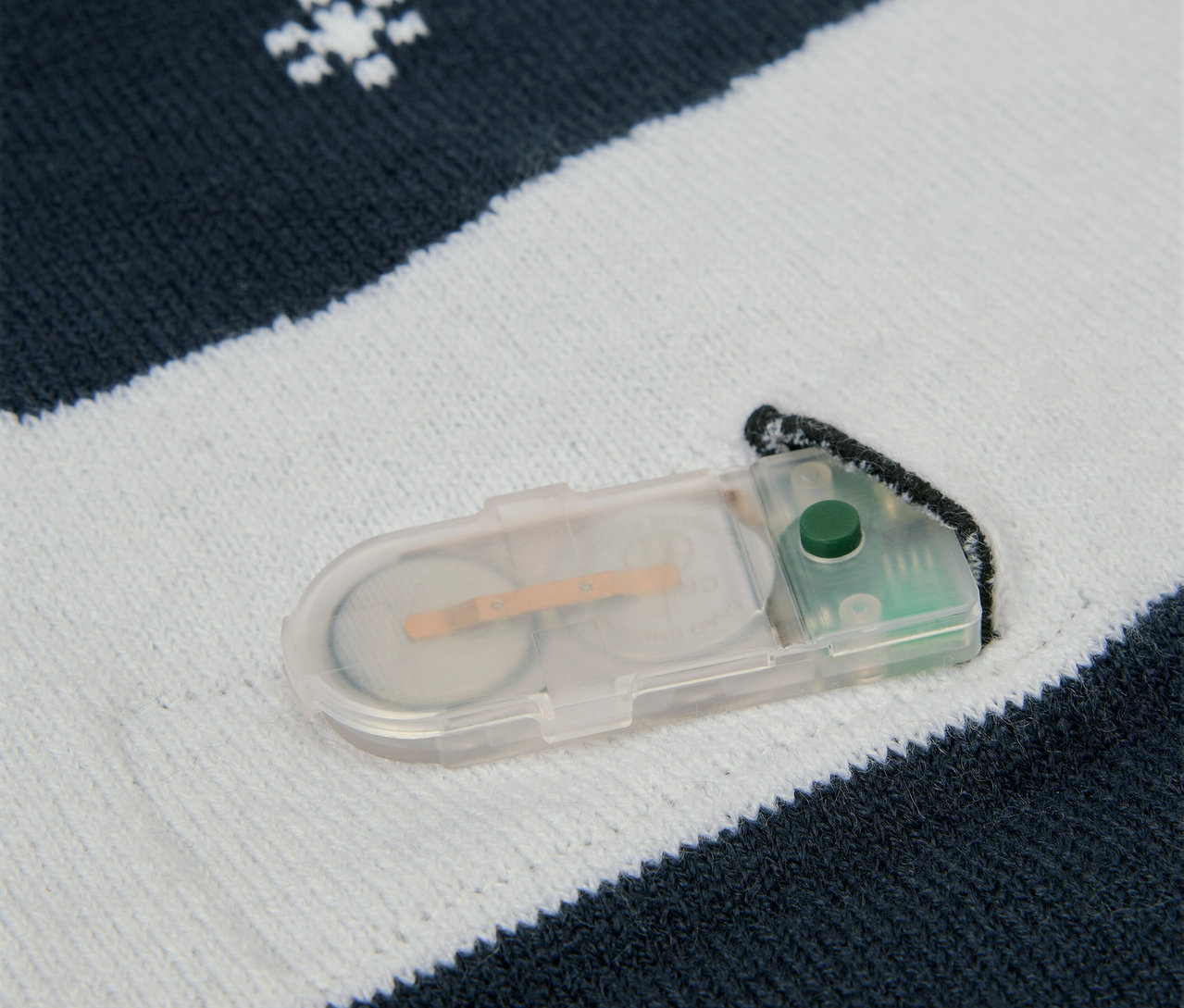 Kötött anyag részlete hópihékkel és egy elemtartóval