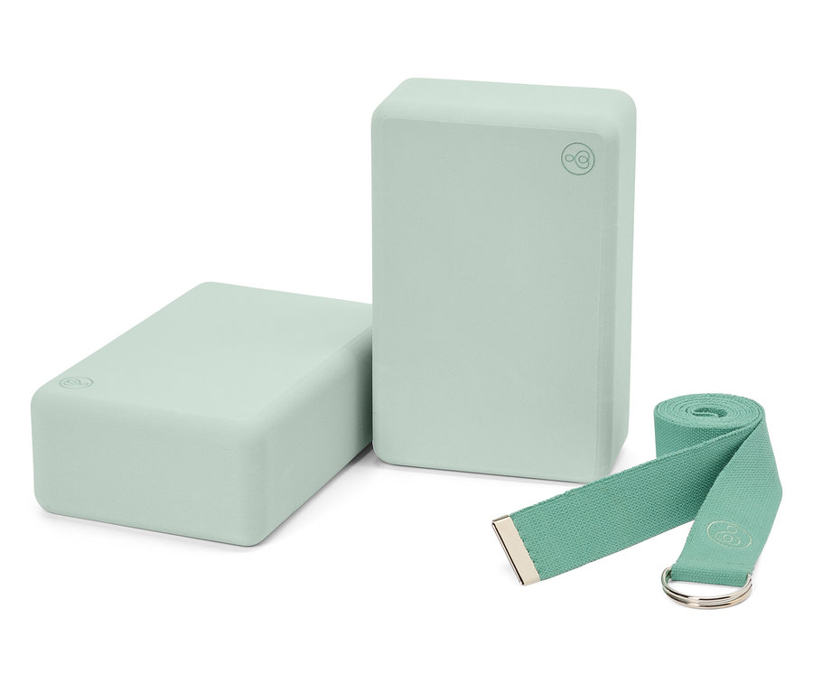 Két világoszöld jógatégla és egy hozzáillő heveder.