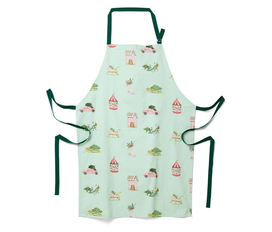 Világoszöld kötény karácsonyi mintával, házakkal, autókkal, szánokkal és körhintákkal.