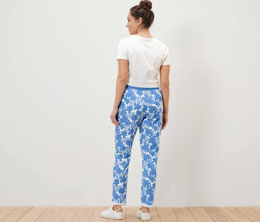 Egy nő áll háttal, nyomott mintás szabadidőnadrágot visel.