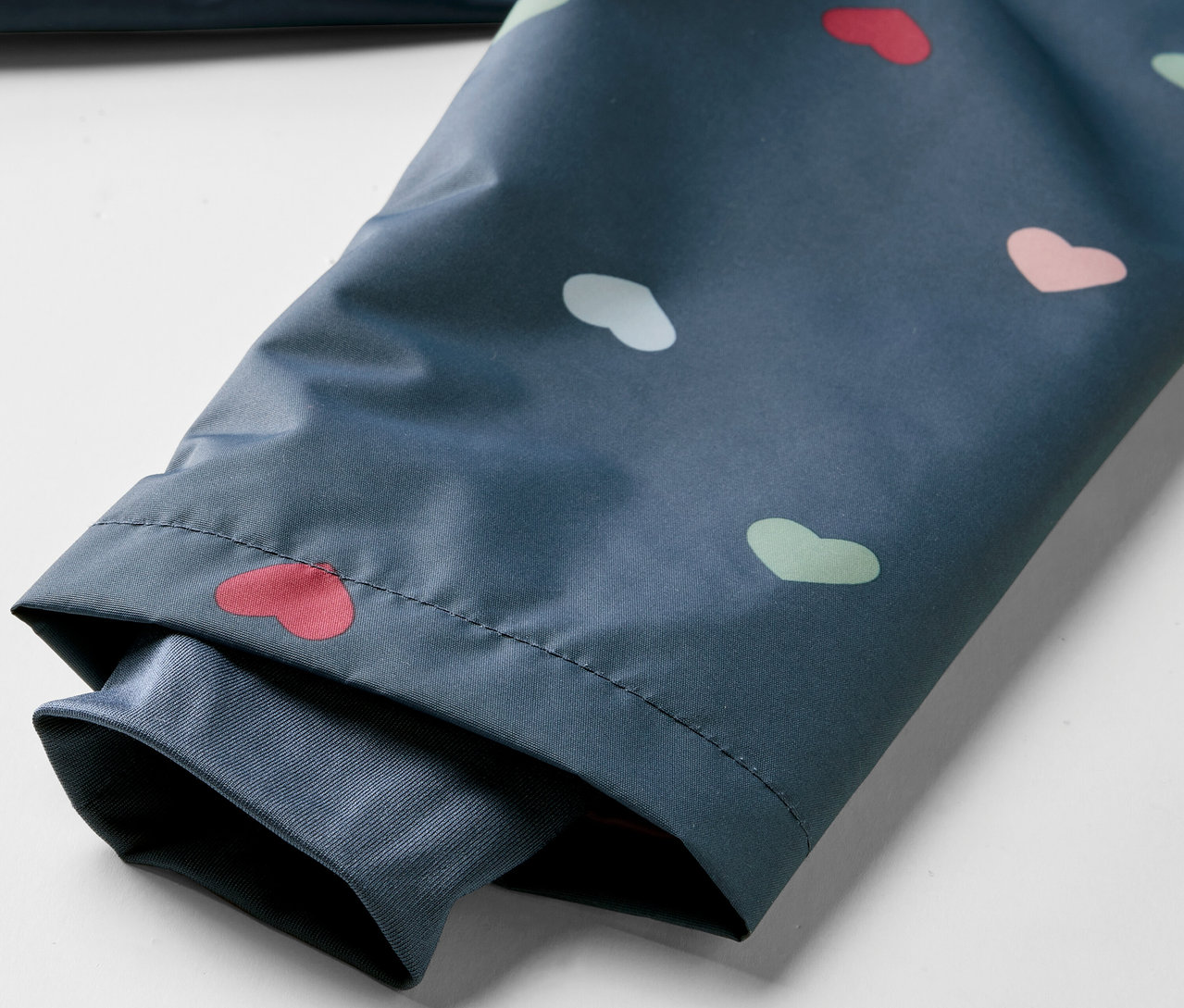 Egy gyerek termo esőkabát részlete, szívecske mintával.