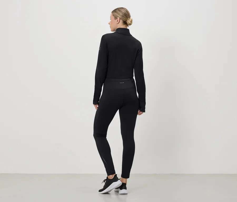 Hátulról látható nő fekete sportruhában, amely egy felsőből, leggingsből és sportcipőből áll, fehér háttér előtt.