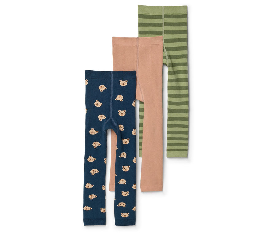 Három gyerek leggings fekszik egymáson: egy sötétkék macikkal, egy világosbarna és egy zöld csíkos.