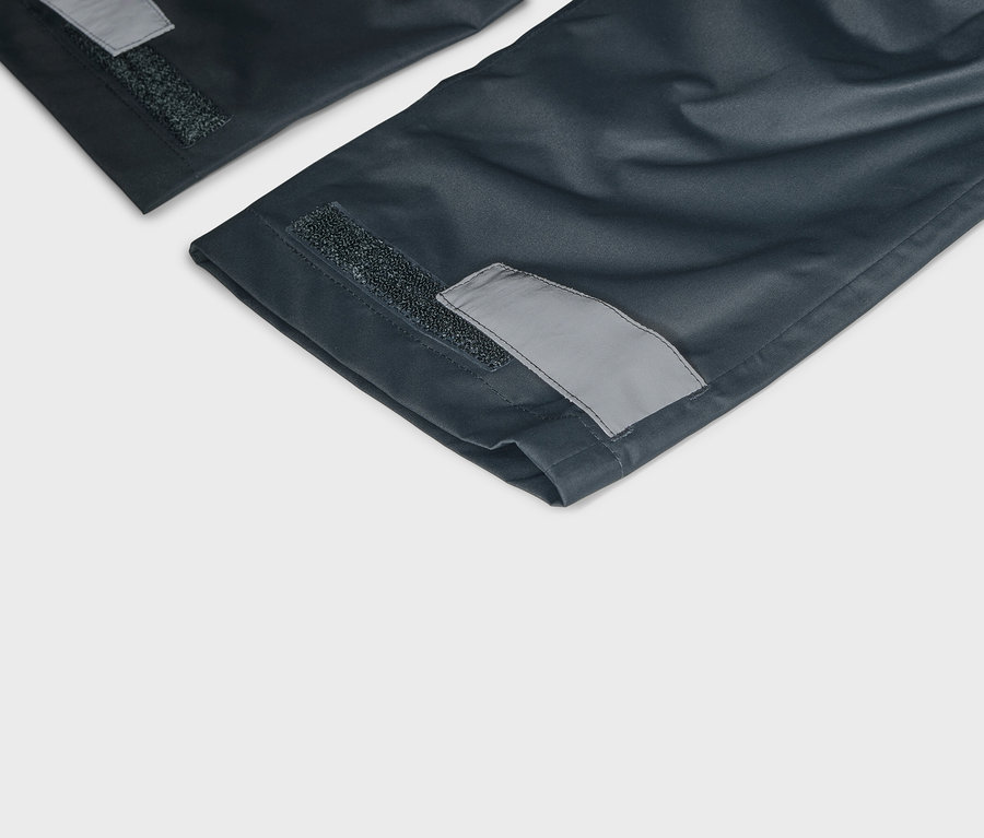 A tengerészkék nadrágszárak részletes képe tépőzárral és fényvisszaverő részletekkel a szegélyeken.